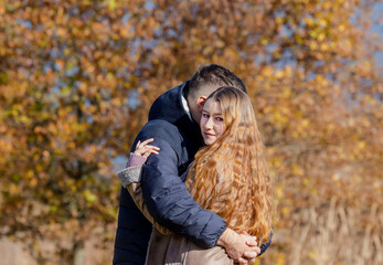 Young married couple hugging in the autumn park