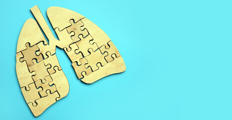 Wooden lungs from pieces of puzzles on the blue background.