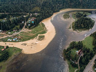 Top view of the oases. A huge lake with clear water around the sand, beaches and trees. Forest and flattering terrain. Bird's eye view of nature landscape