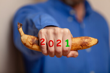 Man hand in shirt holds banana. Numbers on fingers