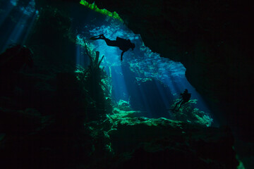 Two divers exploring hidden reefs in the cenote underwater cave of Quintana roo, Mexico
