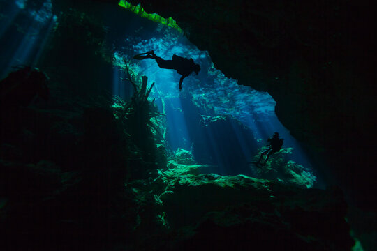Two divers exploring hidden reefs in the cenote underwater cave of Quintana roo, Mexico