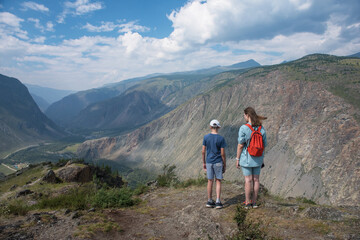 Obraz premium Woman an her son on the viewpoint of valley of the river of Chulyshman. Altai mountains, Russia, beautiful summer day, Travel concept