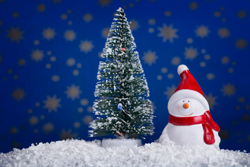 Snowman doll with Christmas tree on starry blue background