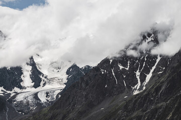 Atmospheric alpine landscape with massive hanging glacier on giant mountain. Big glacier tongue on...