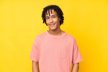Young african american man isolated on yellow background laughing