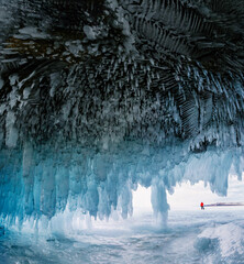 Ice cave frozen lake Baikal in Siberia, Russia.  Silhouettes of a person outside. 