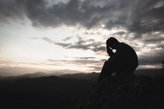Sad man silhouette worried on the mountain. Drug addiction, failure concept.