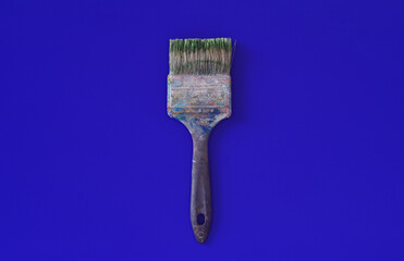Dirty wide working paintbrush on blue background