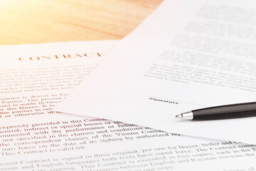 Obraz premium Legal contract signing - buy sell real estate contract. Pen lying on a contract or application form. Close up.