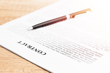 Legal contract signing - buy sell real estate contract. Pen lying on a contract or application form. Close up.