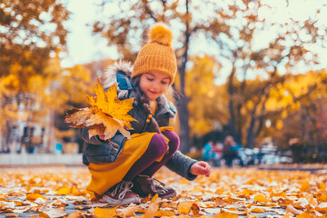 Children in the park with autumn leaves