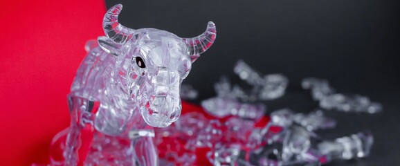 Broken figurine of a bull from three dimensional puzzles on red and gray background. Symbol of...