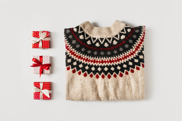 Fashion flat lay knolling with cozy sweater and gift box on white background