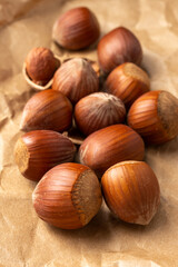 hazelnuts close-up, with selective focus, on brown paper, vertically