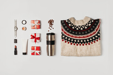 Fashion flat lay knolling with cozy sweater and gift box on white background