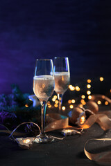 Christmas card two glasses of champagne on a neon colored background with a garland