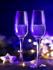 Two glasses of champagne, celebrate Christmas and new year. The bright colors of the holiday and neon light