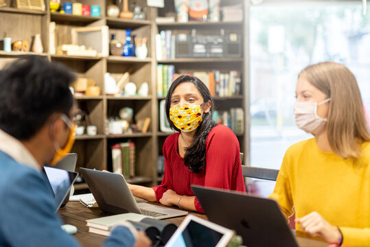 Young Indian Woman With Facial Mask Working Together With A Team, Start Up And Coworking Of Young Multiracial Entrepreneurs, The New Normal Concept Of Social Collaboration