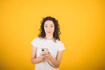 Stylish beautiful girl portrait on a yellow background with a phone