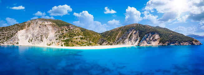 Wide panoramic aerial view to Myrtos beach and the coast of Kefalonia, Greece, with turquoise sea and sunshine during summer time