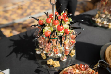 The close up of a set of canapes and snack at a banquet with black table