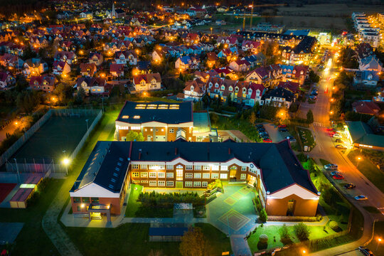 Aerial landscape of illuminated streets and elementary school in Rotmanka, Poland. © Patryk Kosmider