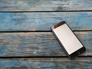 smart phone on wooden floor, top view