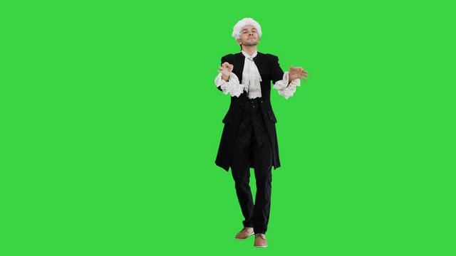 Man dressed like Mozart conducting expressively while looking at camera on a Green Screen, Chroma Key.