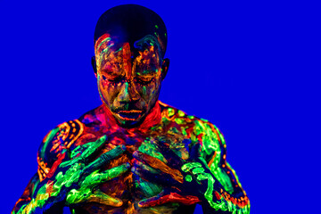 afro american man with UV body art posing in studio