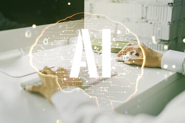 Creative artificial Intelligence concept with human brain hologram and hands typing on laptop on background. Multiexposure