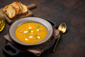 Pumpkin soup with shrimps and basil oil with toasted bread. Copy space.