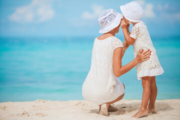 Beautiful mother and daughter at the beach enjoying summer vacation