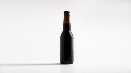 Cold full glass dark bottle of beer, isolated on white background