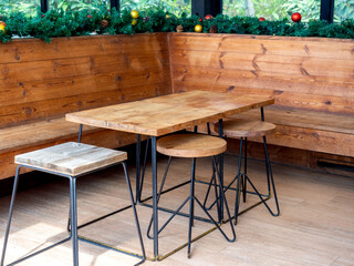 Empty wooden table and wooden chairs with Christmas ornament object decorations.