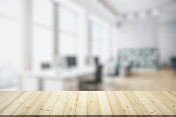Blank wooden tabletop with bright furnished office on background, mockup