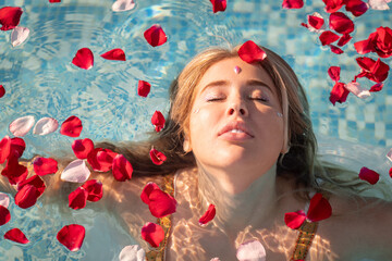Obraz na płótnie Canvas beautiful woman in a pool with flowers