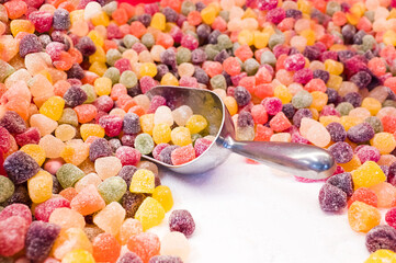 A metal scoop in a pile of boiled sweets on a stall at Christmas market