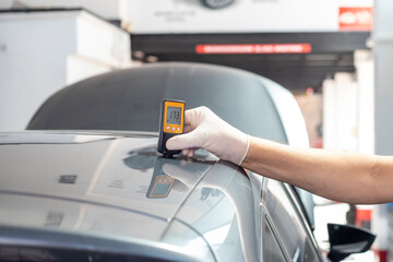 Fototapeta premium Checking the thickness of car paint using an electronic sensor