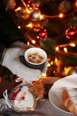 hands in mittens hold a hot cup of coffee. Coffee to go in winter