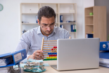 Young male bookkeeper calculating tax payments in the office