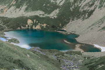 Blue lake in the mountains and horses near