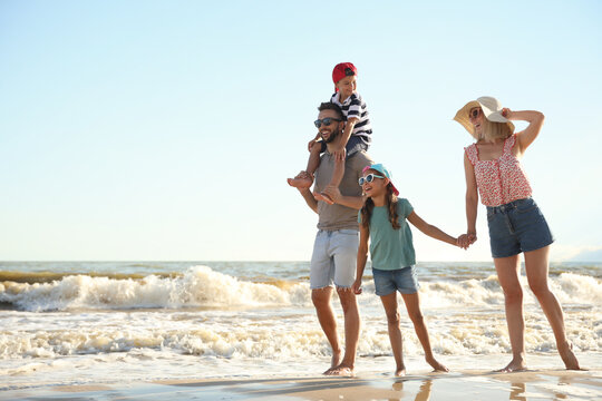 Happy family on sandy beach near sea