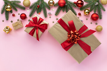 Christmas holiday composition. Xmas tree fir branches, colorful balls, gift boxes on pastel pink background. Christmas, New Year concept