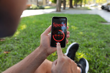 Man using fitness app on smartphone outdoors, closeup