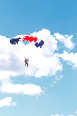 skydiving in the clouds. colorful parachute on the blue sky background