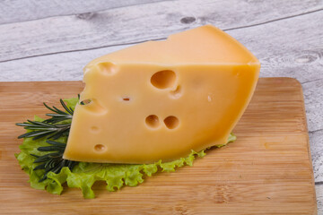 Maasdam cheese  in the board served salad leaves