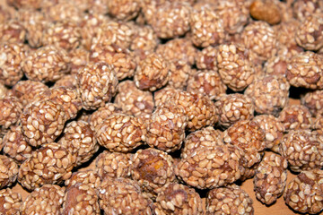 close - up of roasted peanuts with sesame and honey, on wooden background.  selective focus