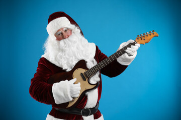 Santa Claus playing electric guitar on blue background. Christmas music