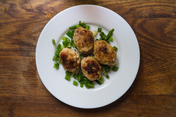 Homemade pork-beef cutlets or meatballs in a bowl, rustic style, vintage wooden background, top view